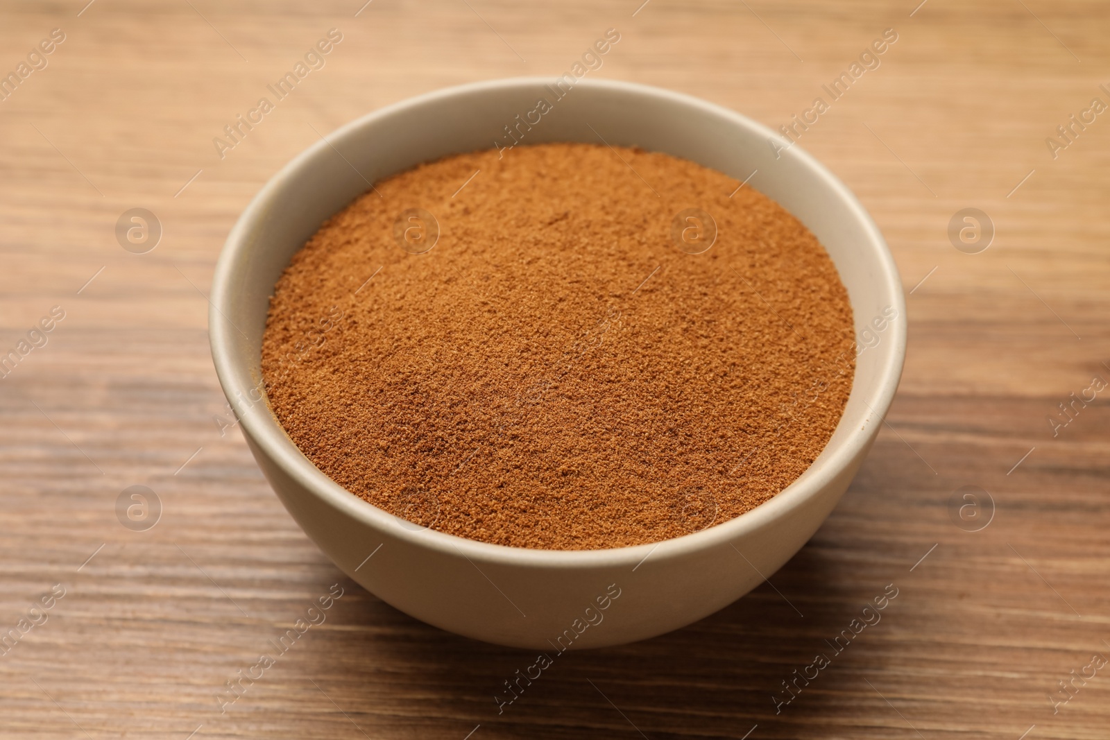 Photo of Bowl of chicory powder on wooden table