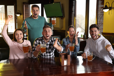 Photo of Group of friends watching football in sport bar