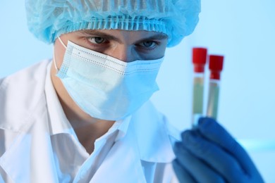 Photo of Scientist working with samples on light blue background, closeup. Medical research