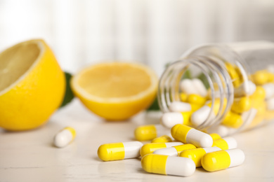 Photo of Bottle with vitamin pills and lemon on light table, closeup