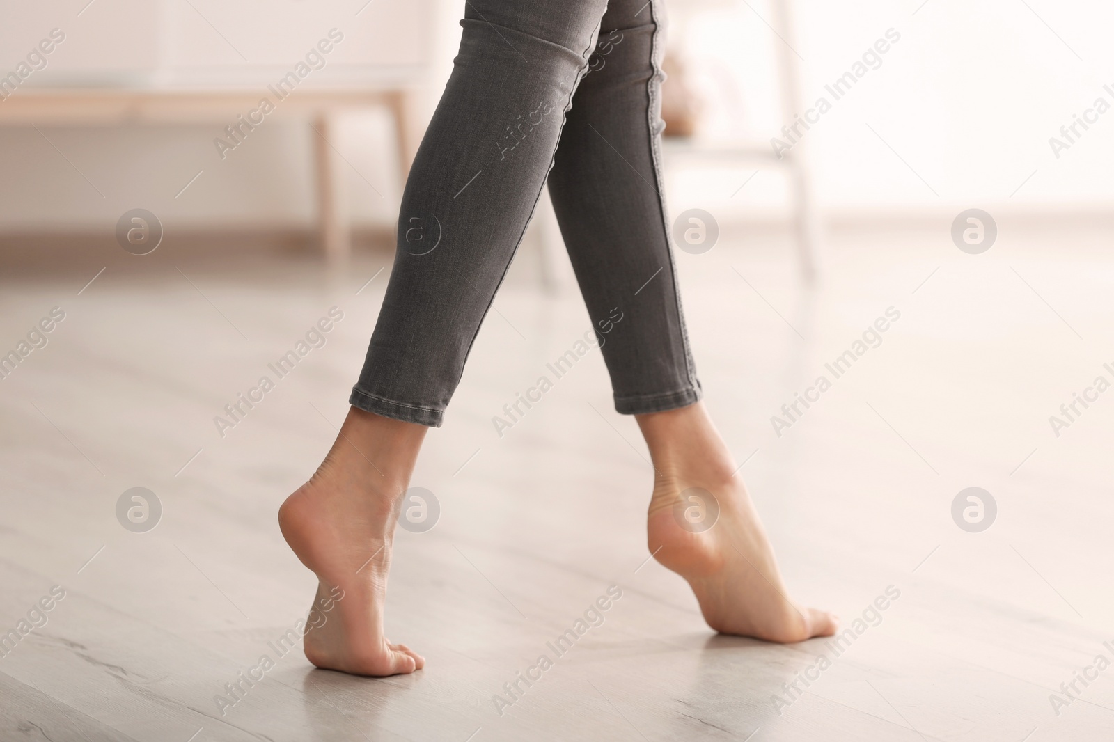 Photo of Young woman walking barefoot at home, closeup. Heating concept