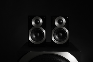 Photo of Modern powerful audio speaker system on black background