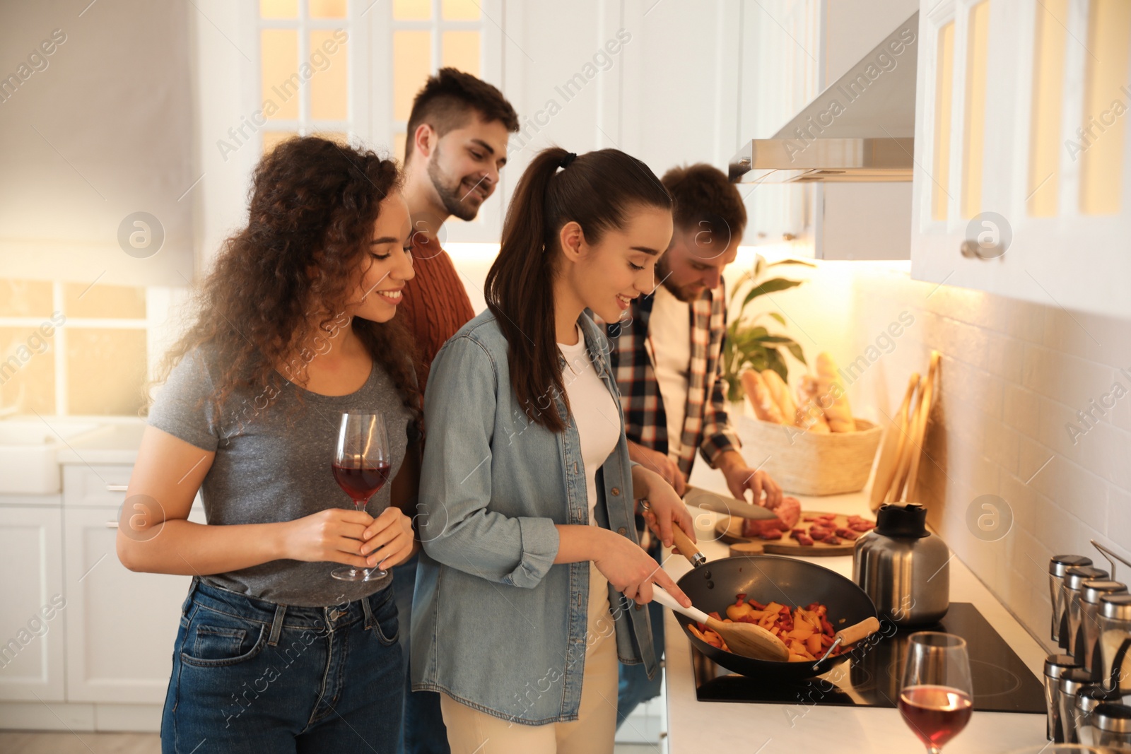 Photo of Happy people cooking food together in kitchen