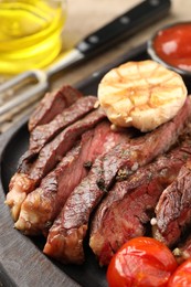 Photo of Delicious grilled beef with tomatoes and spices on table, closeup