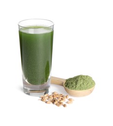 Photo of Wheat grass drink in shot glass, seeds and spoon of green powder isolated on white