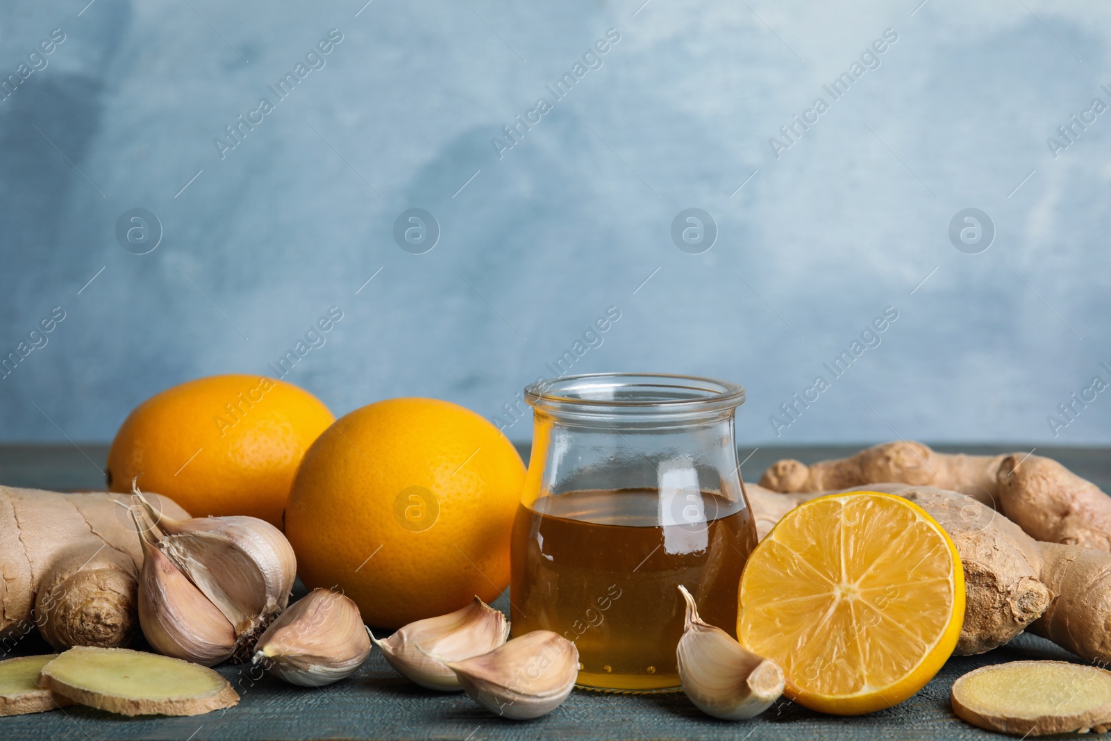 Photo of Fresh garlic and other natural cold remedies on light blue wooden table, space for text