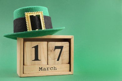 St. Patrick's day - 17th of March. Block calendar and leprechaun hat on green background. Space for text