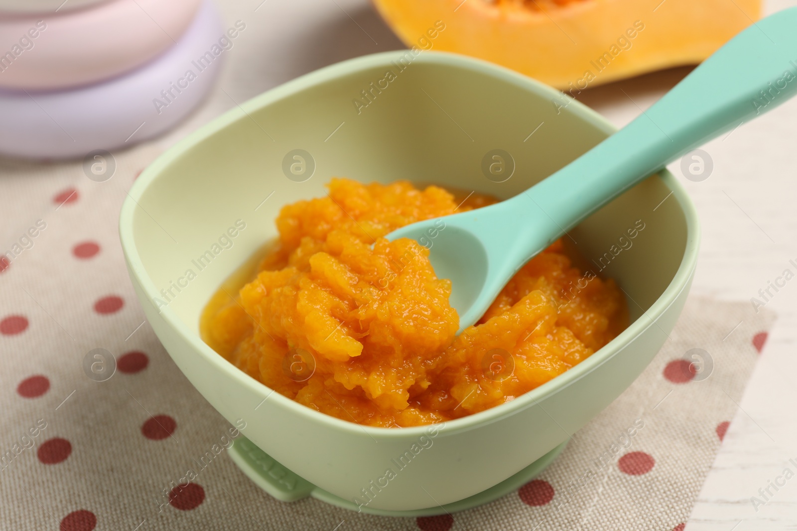 Photo of Baby food. Tasty pumpkin puree on white wooden table, closeup