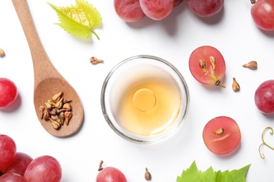 Photo of Composition with bowl of natural grape seed oil on white background, top view. Organic cosmetic