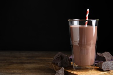 Photo of Delicious chocolate milk on wooden table. Space for text