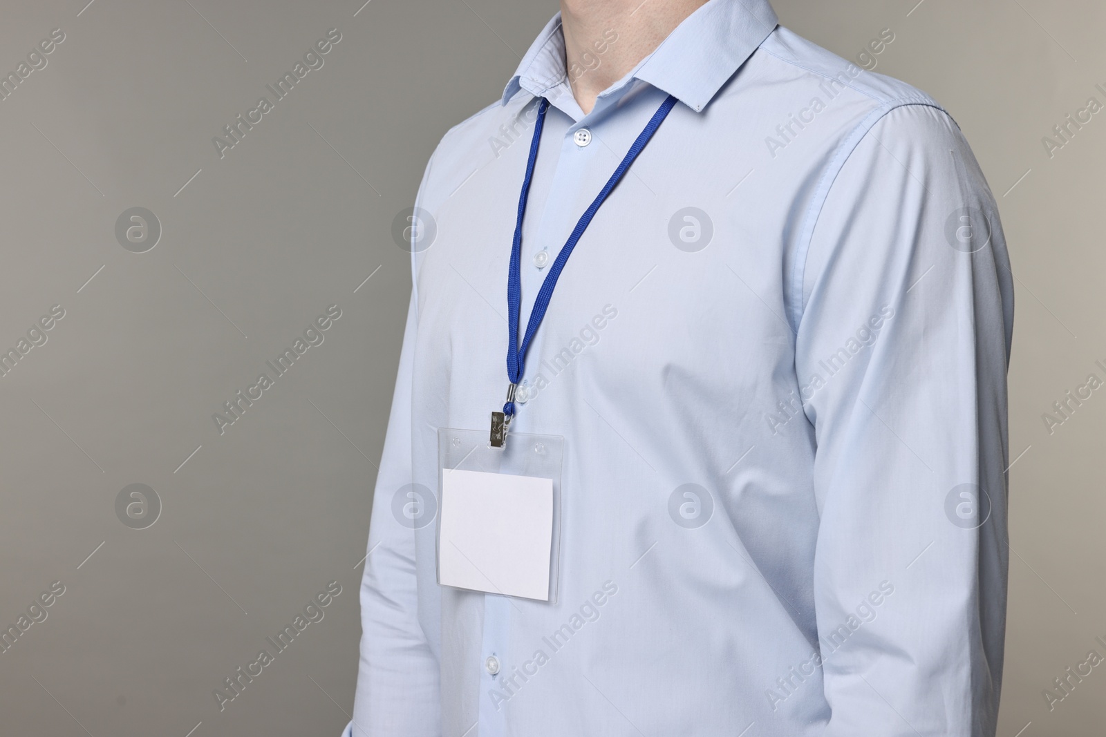 Photo of Man with empty badge on grey background, closeup. Space for text