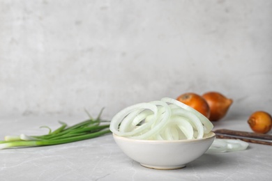 Photo of Bowl with fresh onion rings on table