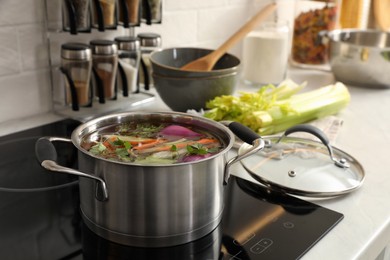 Photo of Pot of delicious vegetable bouillon on stove in kitchen