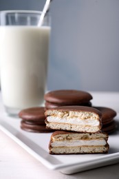 Photo of Tasty choco pies and milk on white wooden table