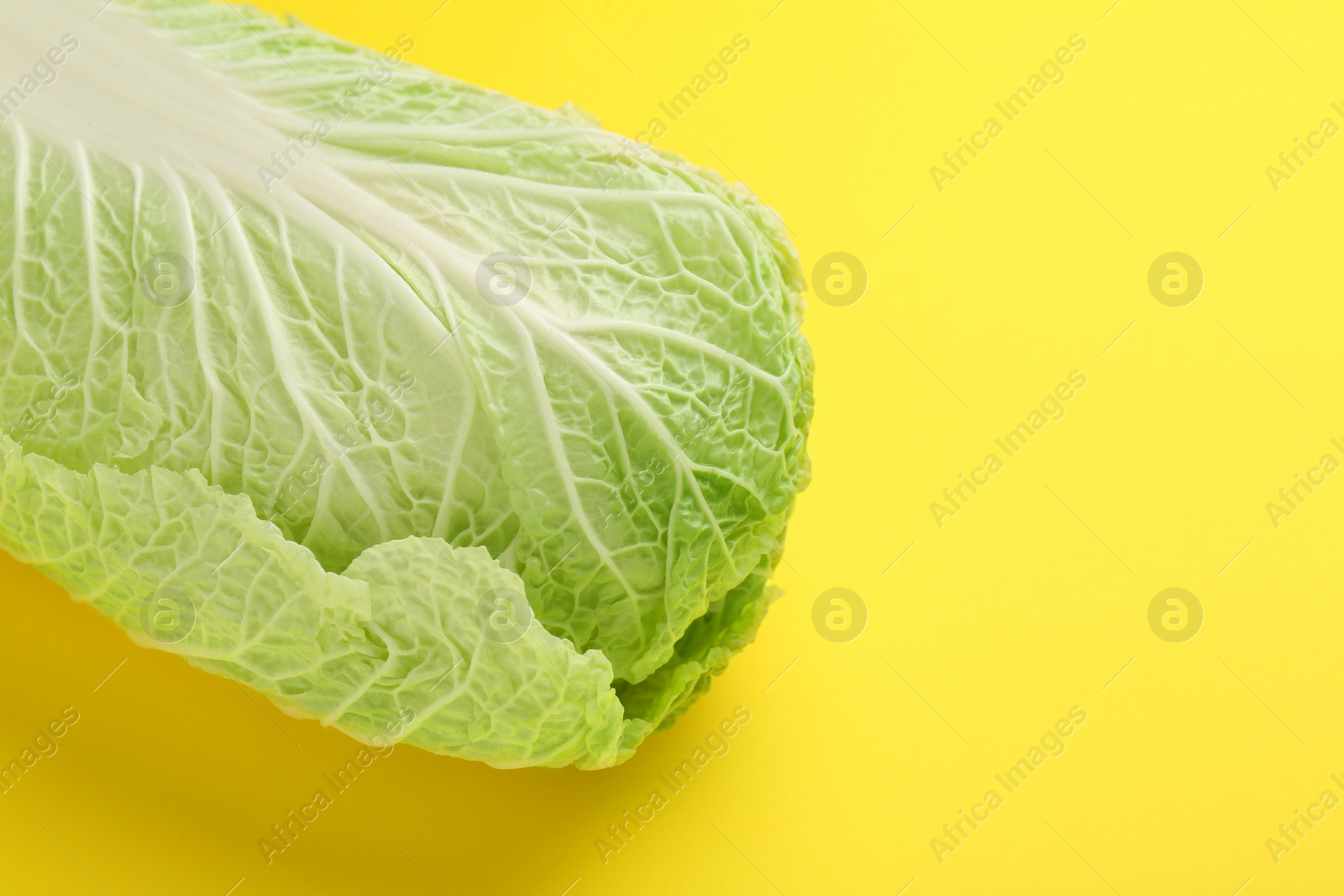 Photo of Fresh ripe Chinese cabbage on yellow background, space for text