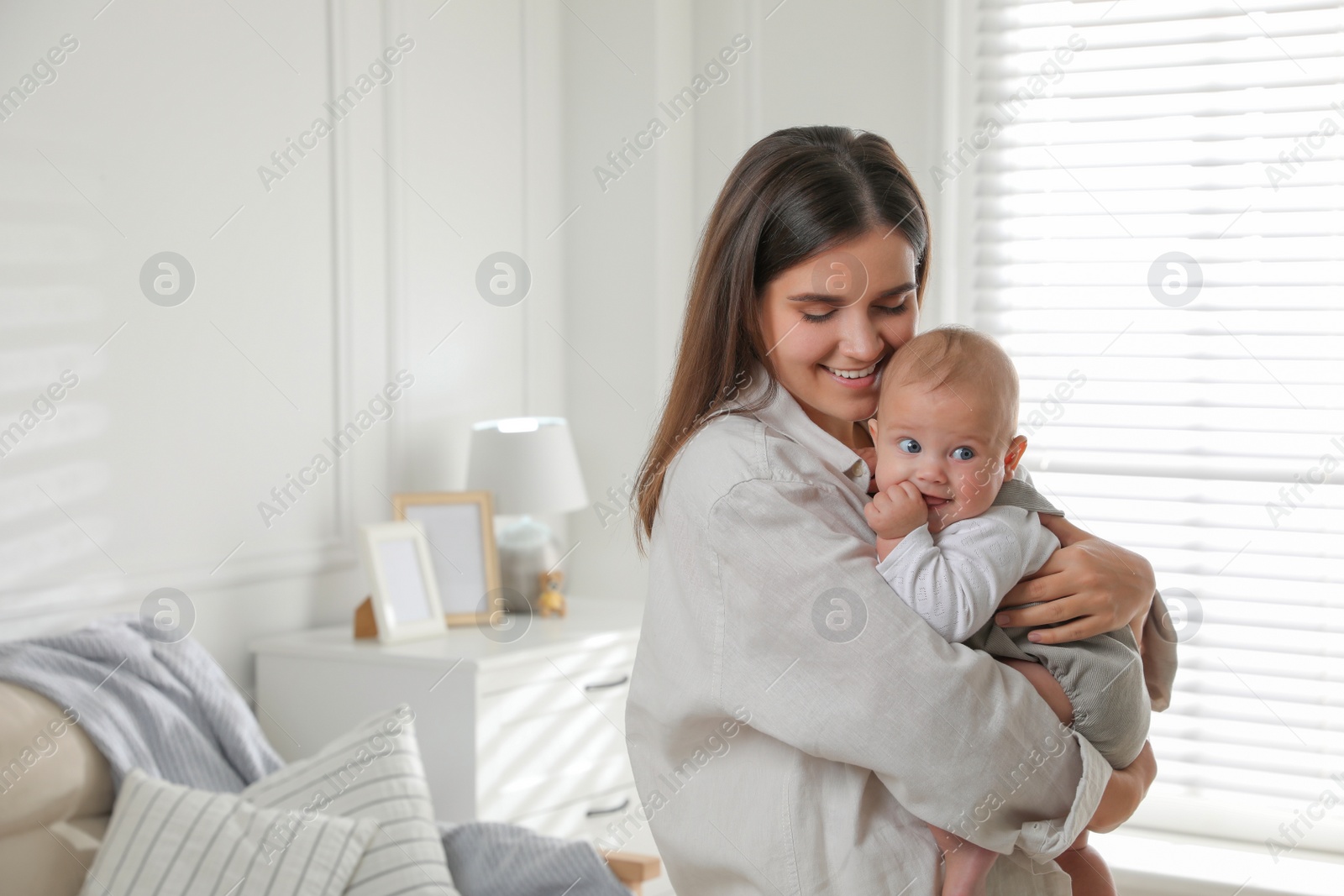 Photo of Young woman with her little baby at home