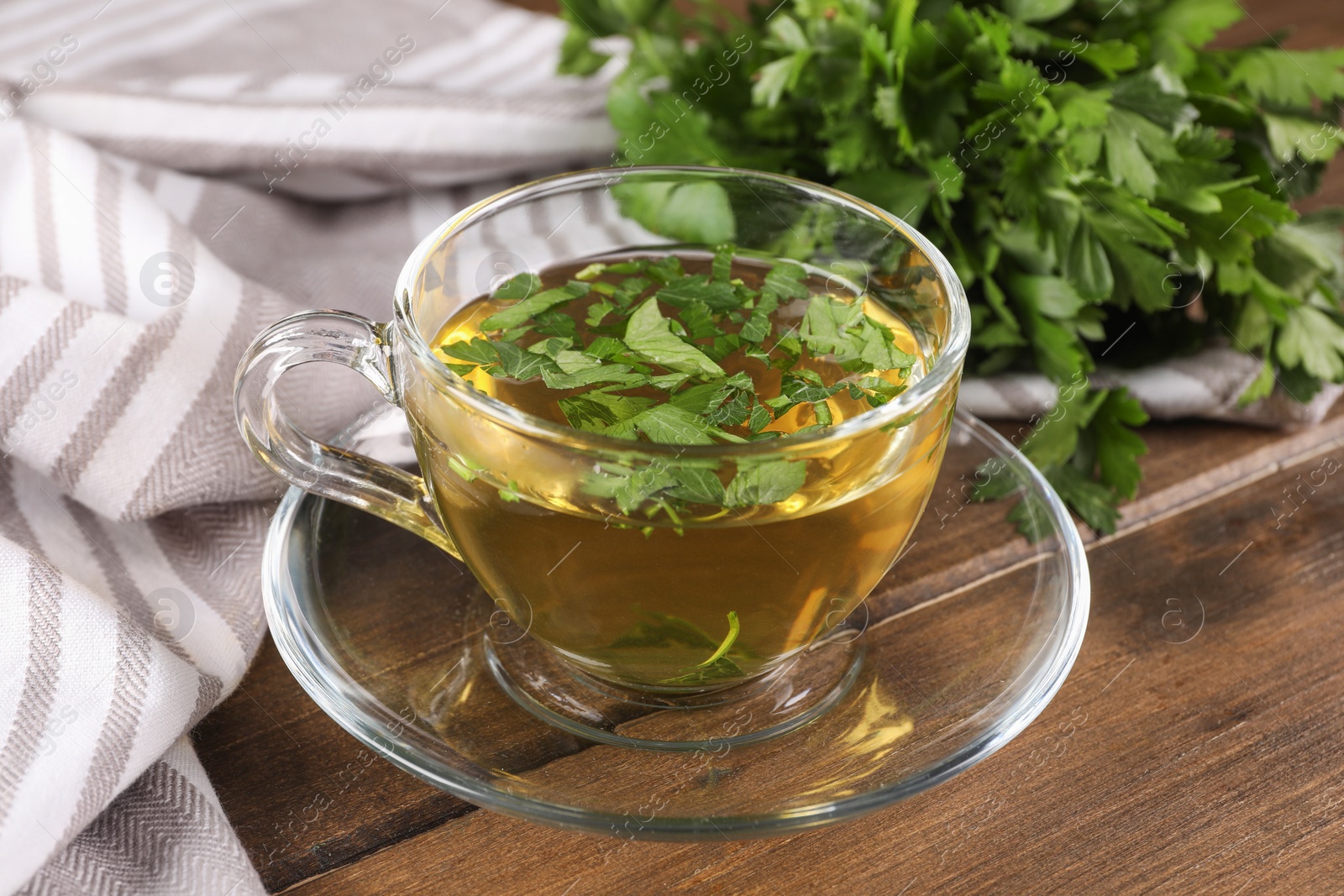 Photo of Aromatic herbal tea with parsley on wooden table, closeup