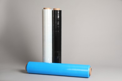 Photo of Rolls of different stretch wrap on light grey background