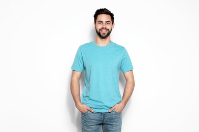 Photo of Young man in t-shirt on light background. Mock up for design