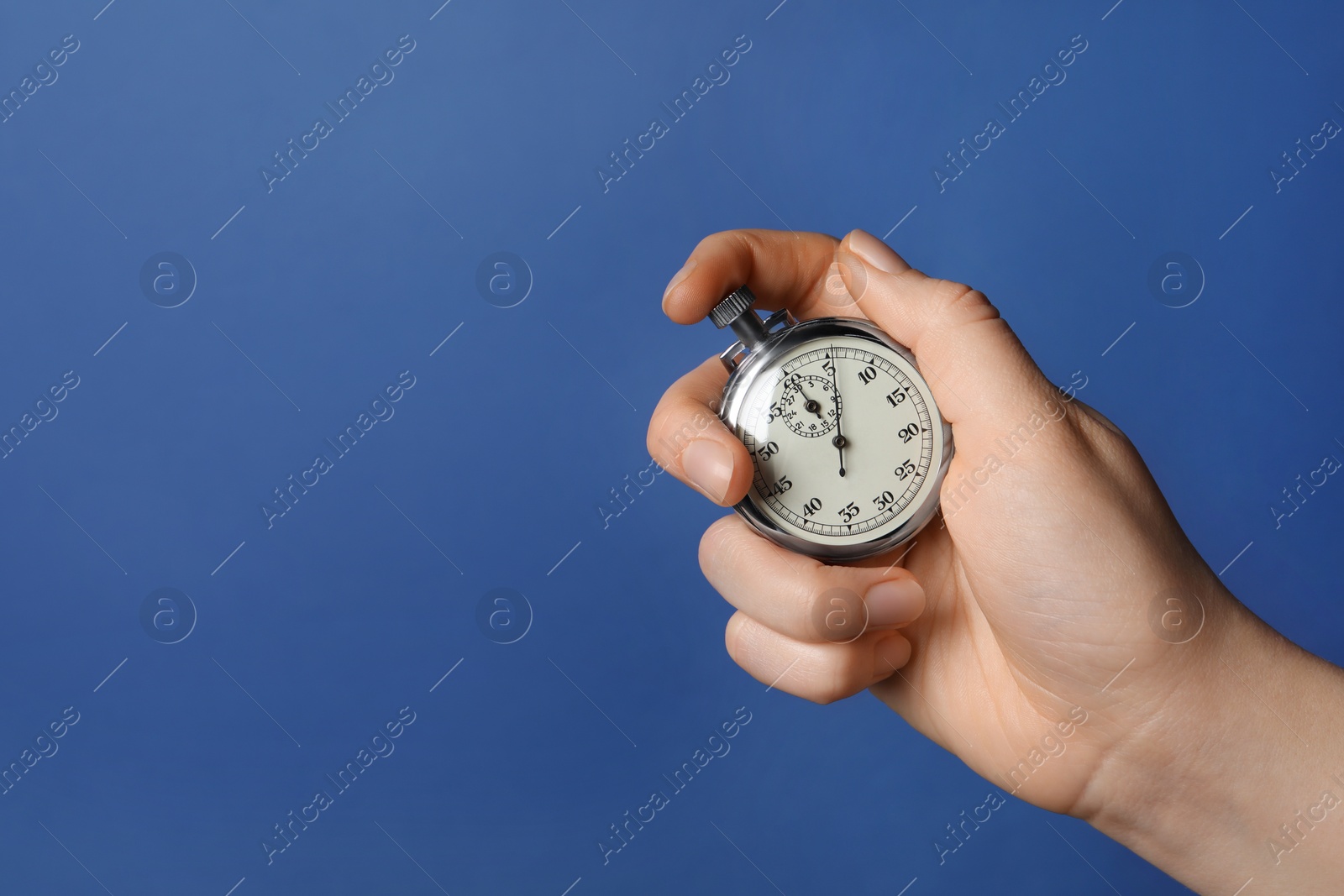 Photo of Woman holding vintage timer on blue background, closeup. Space for text