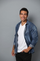 Photo of Handsome young African-American man on grey background