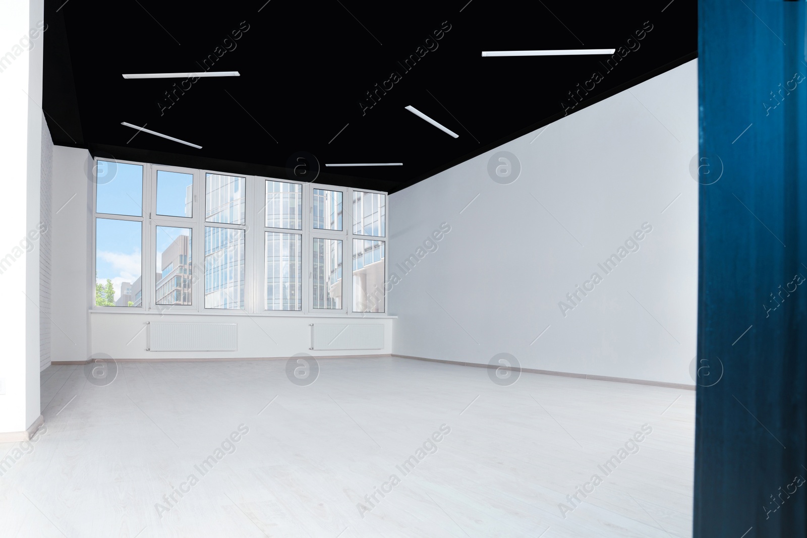 Photo of Empty office room with black ceiling and windows. Interior design