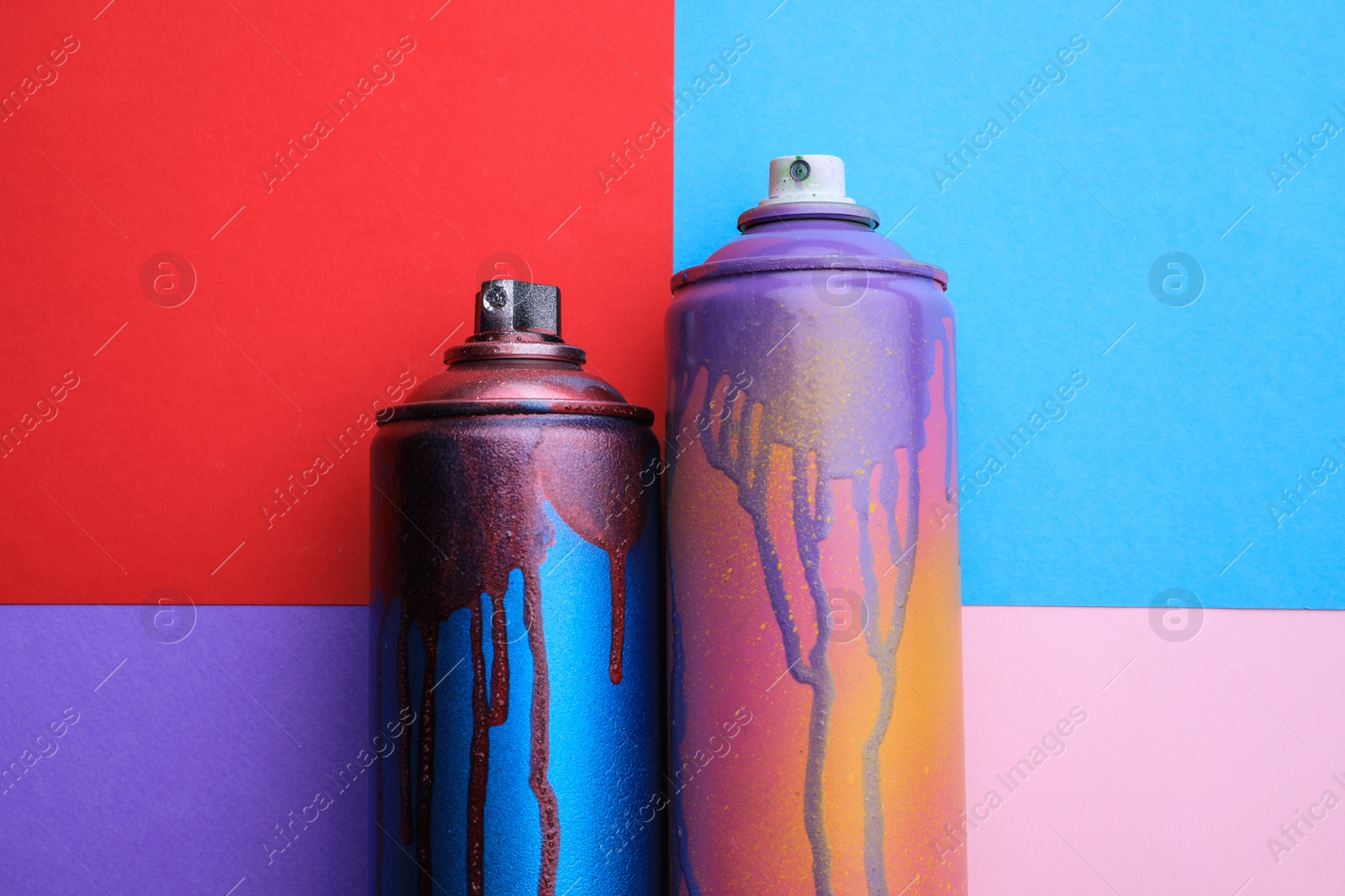 Photo of Used cans of spray paints on color background, flat lay. Graffiti supplies