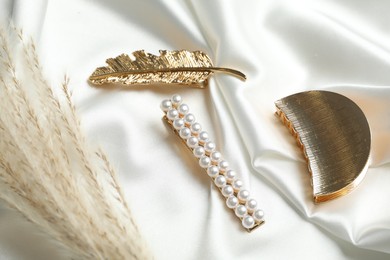 Photo of Beautiful different hair clips on white fabric, above view