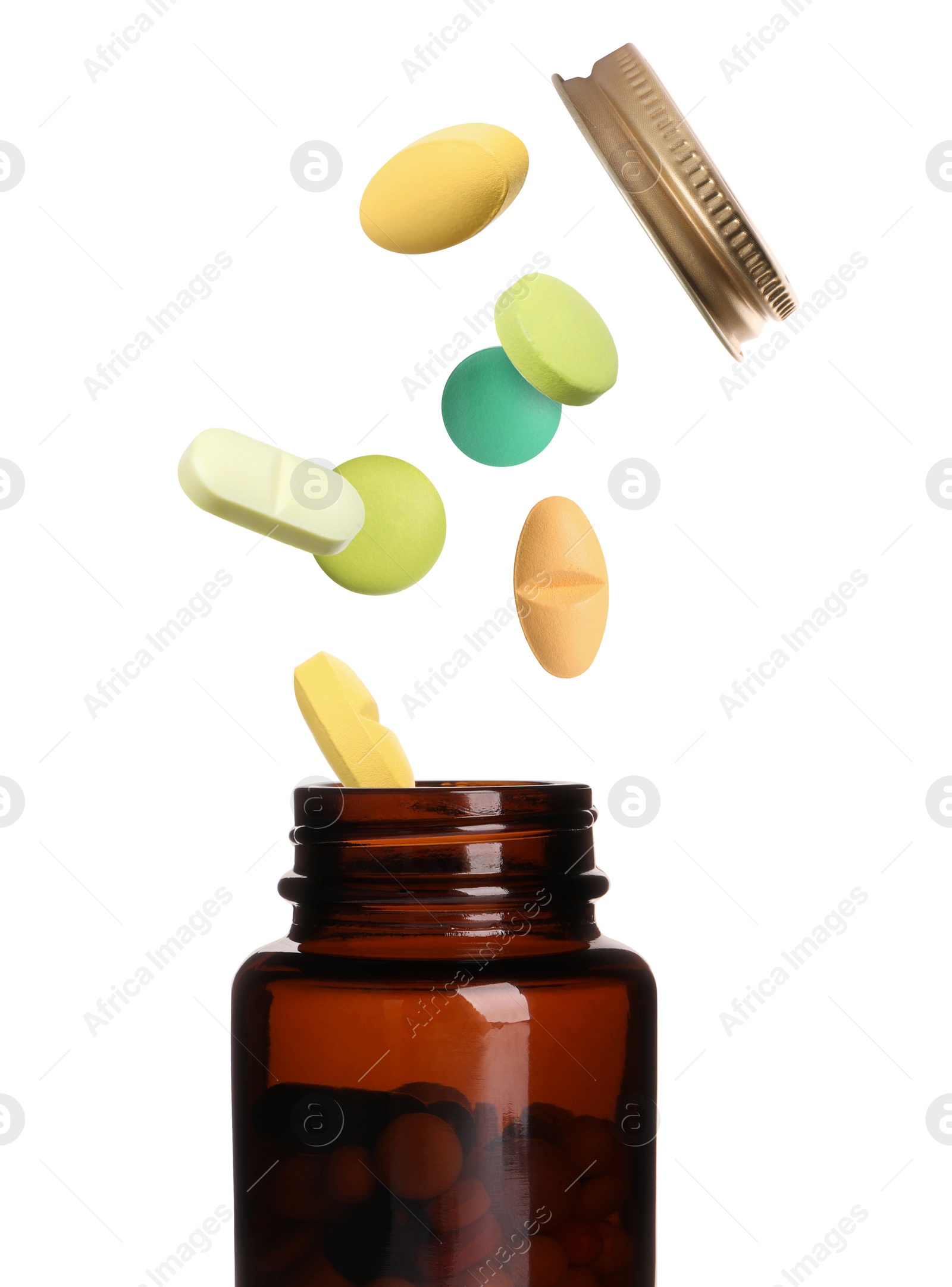 Image of Many different colorful pills bursting out of bottle on white background