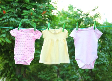 Photo of Baby clothes on laundry line outdoors on sunny day