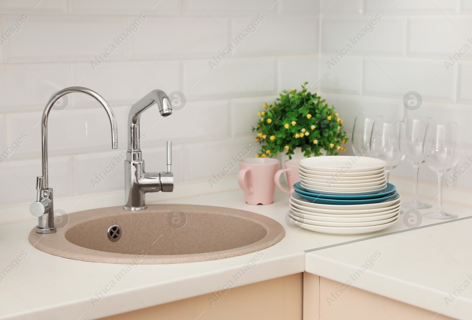 Photo of Clean dishes on counter near kitchen sink indoors