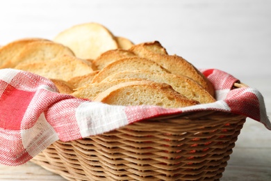 Photo of Slices of toasted bread in basket on white table, closeup