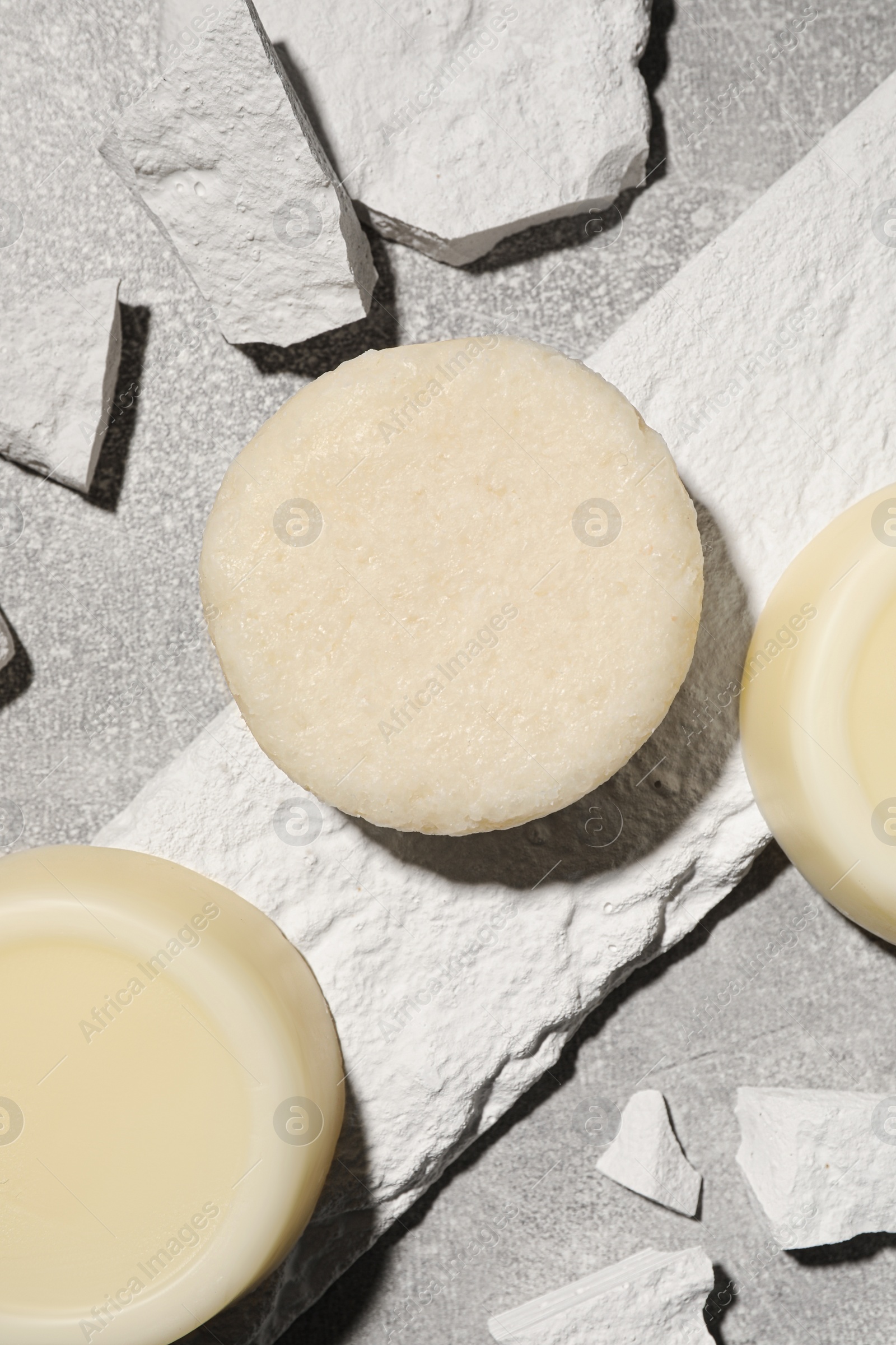 Photo of Solid shampoo bars on light grey table, flat lay