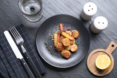 Delicious fried scallops served on dark gray textured table, flat lay