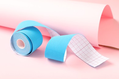 Photo of Bright kinesio tape in roll on pink background