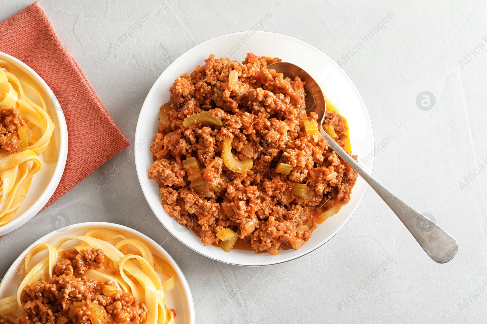 Photo of Plates with delicious pasta bolognese on grey background, top view