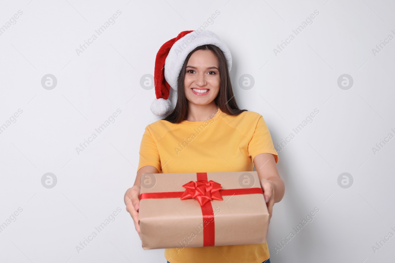 Photo of Young woman with Christmas gift on white background