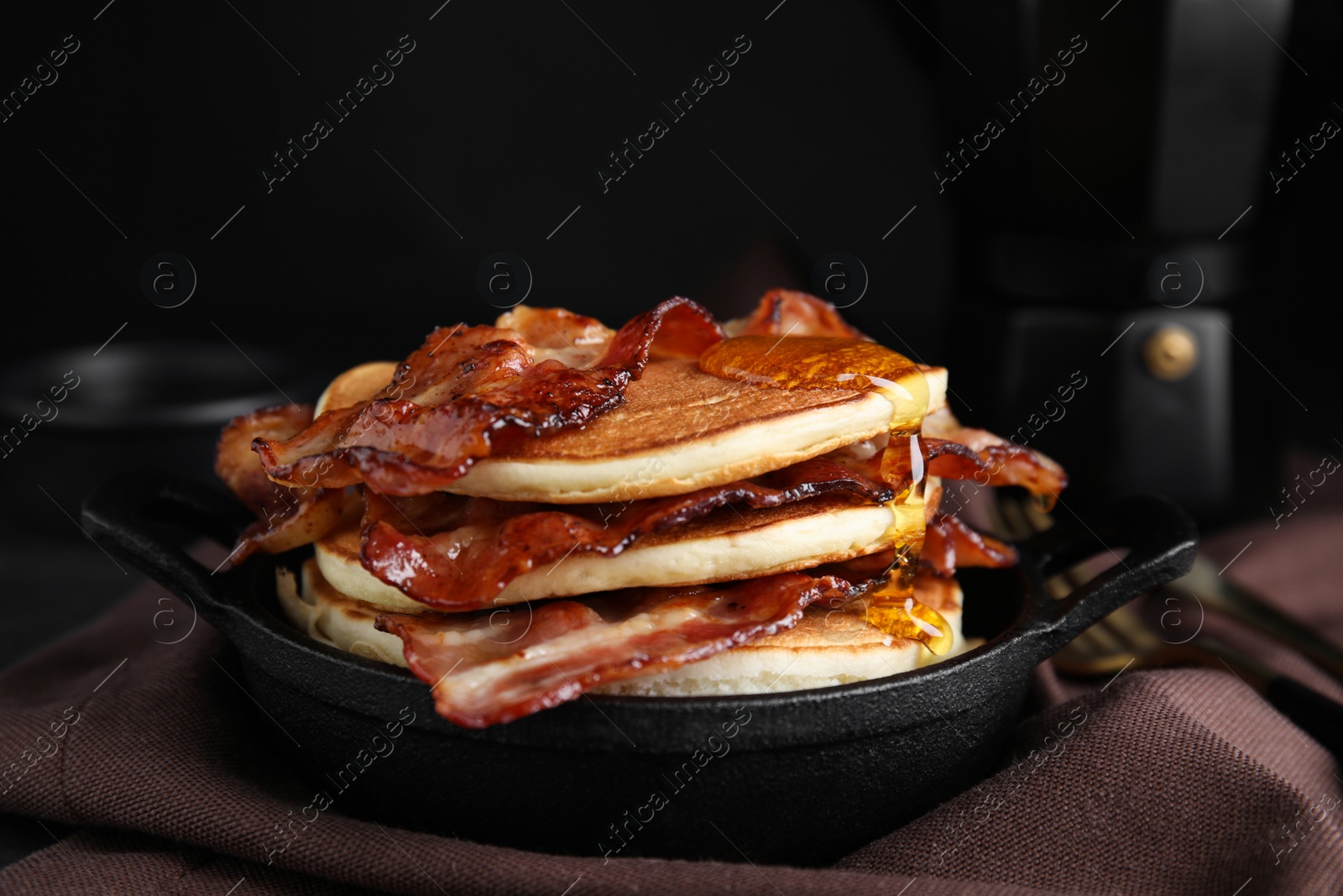 Photo of Delicious pancakes with maple syrup and fried bacon on table, closeup