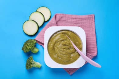 Healthy baby food and vegetables on light blue background, flat lay