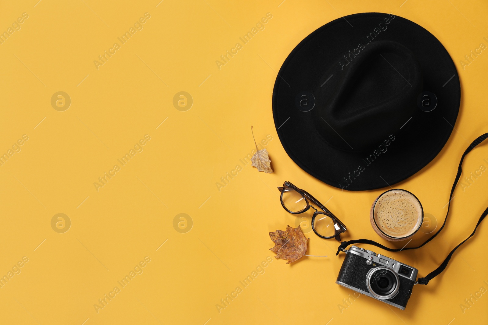 Photo of Flat lay composition with stylish hat on yellow background, space for text