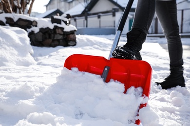 Photo of Person shoveling snow outdoors on winter day, closeup