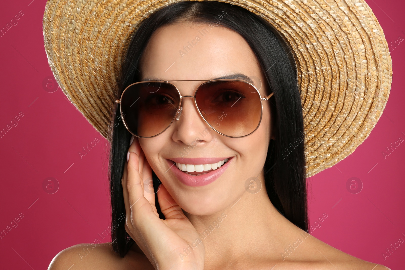 Photo of Beautiful woman wearing sunglasses on pink background, closeup
