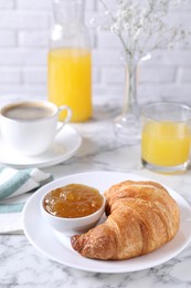 Tasty breakfast. Fresh croissant and jam on white marble table