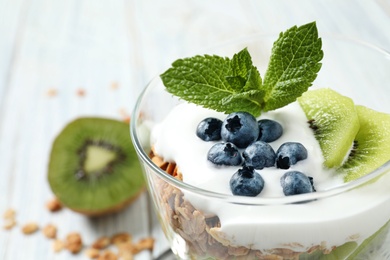 Photo of Tasty homemade granola dessert on white wooden table, closeup. Healthy breakfast