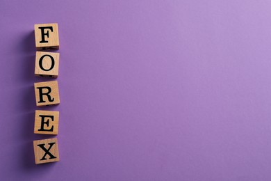 Word Forex made of wooden cubes with letters on purple background, flat lay. Space for text