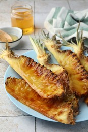 Tasty grilled pineapples on light gray table