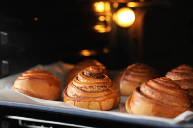 Photo of Tray with freshly baked buns in oven, closeup