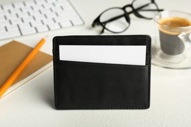 Leather business card holder with card on white table