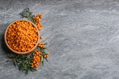 Photo of Fresh ripe sea buckthorn on grey table, flat lay. Space for text