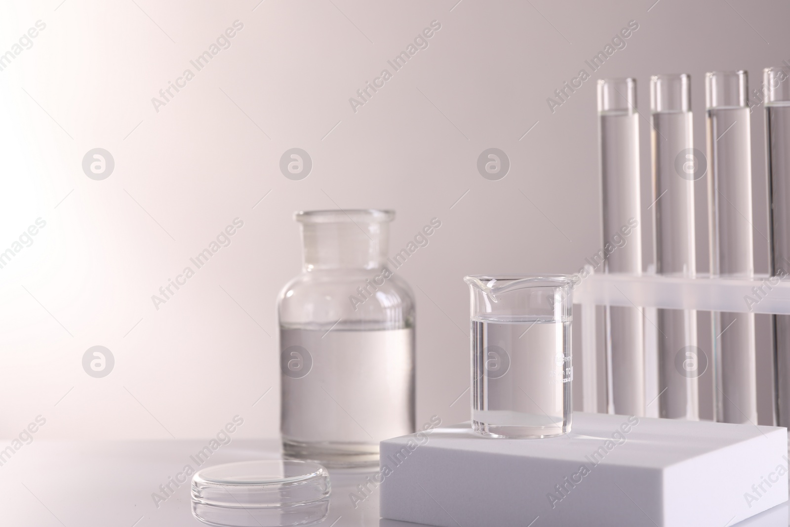 Photo of Laboratory analysis. Different glassware on table against light background, space for text